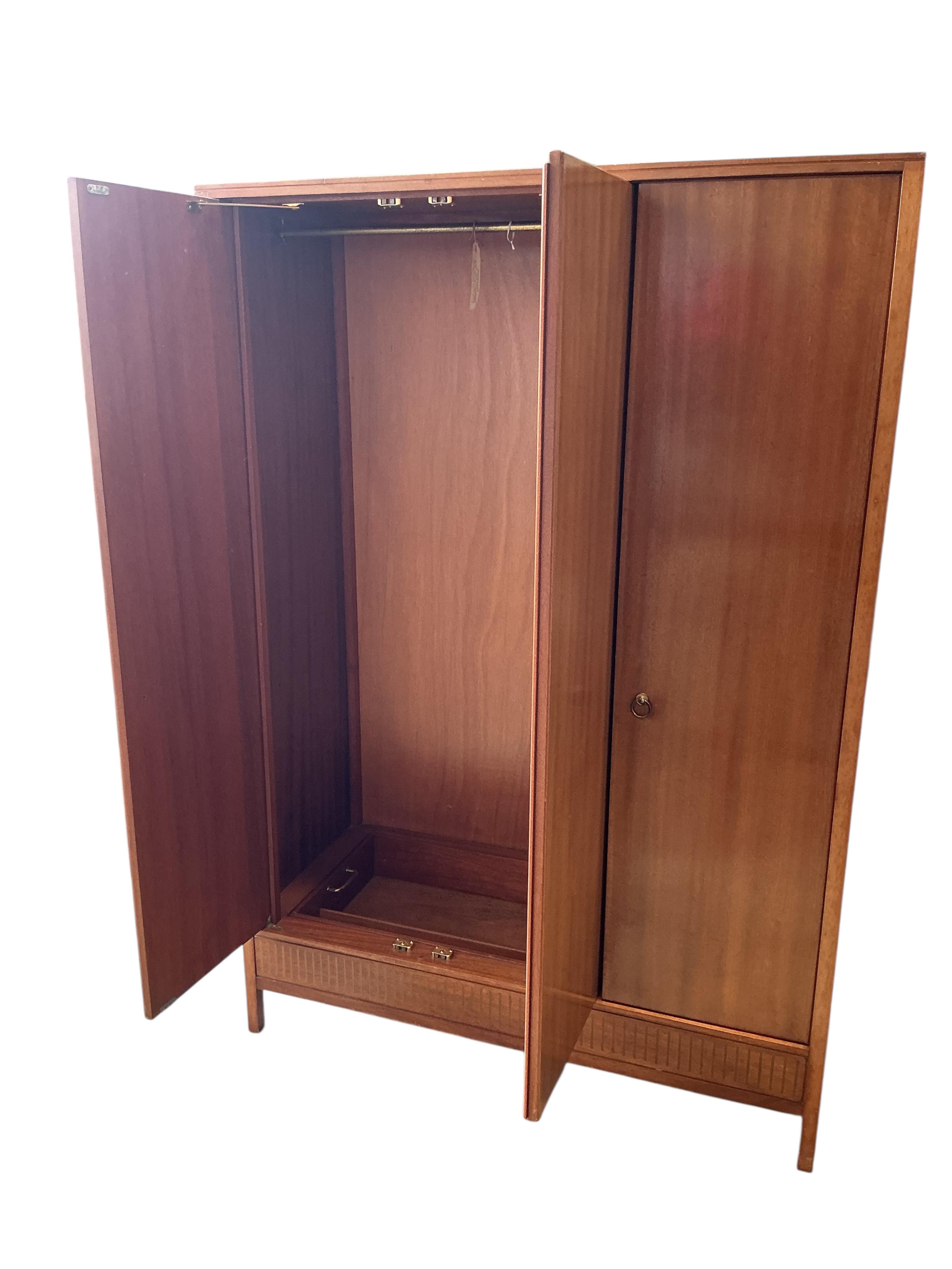 A Loughborough For Heals brass inlaid teak four piece bedroom suite comprising: triple wardrobe, width 120cm, depth 54cm, height 176cm, two chests of drawers and a toilet mirror